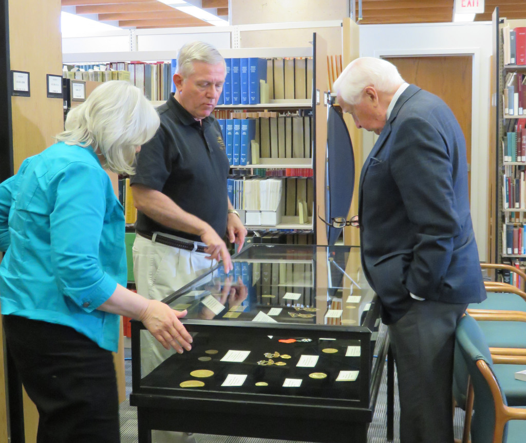 Archivists Dawne Dewey and John Armstrong show David McCullough our display of the Wright Brothers' medals.