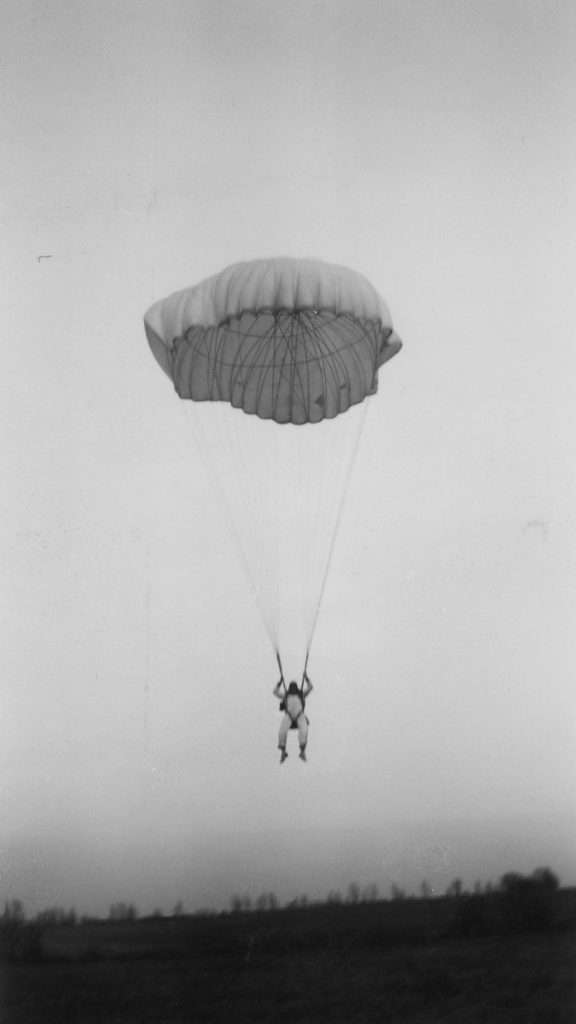 Bob Brown landing via parachute, undated